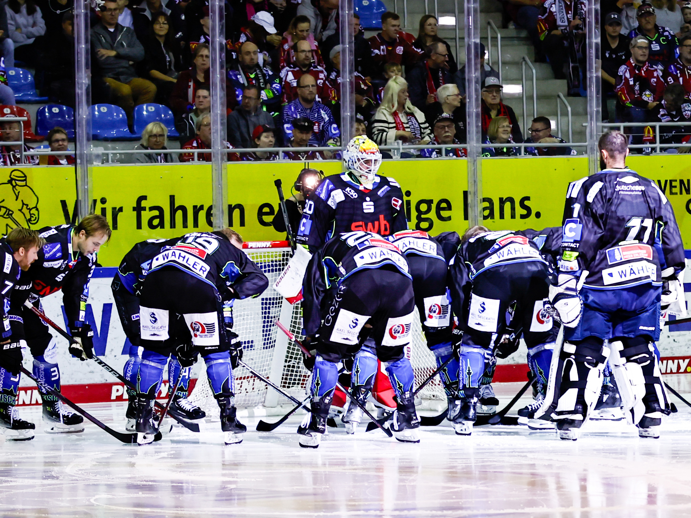 Eishockeymannschaft Fischtown Pinguins Bremerhaven auf dem Eis während eines Spiels